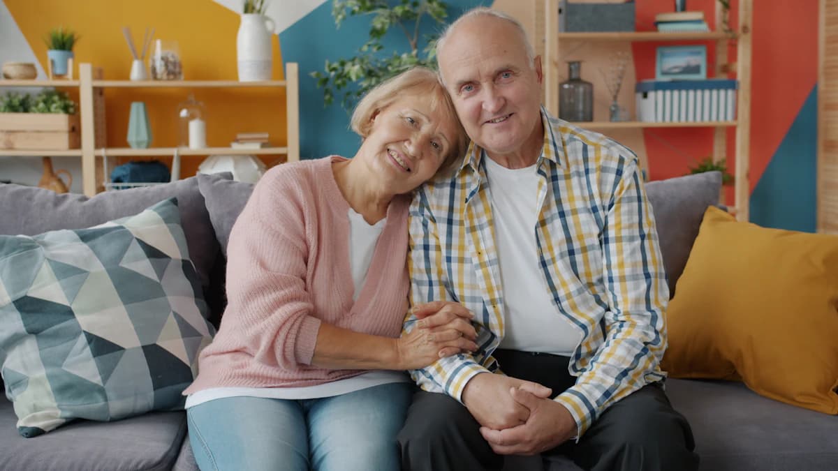 Elderly couple smiling together on a couch